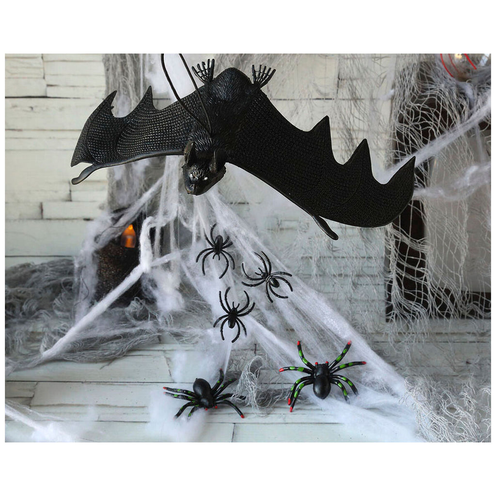 Toile d'araignée Halloween installée sur une cheminée avec chauve-souris et araignées